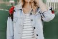 Person wearing a denim jacket with floral embroidery, representing self-expression, confidence, and personal identity