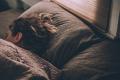 Person resting in bed under a blanket, illustrating sleep, rest, and recovery