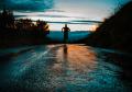 Person running on a wet road at sunrise, symbolizing perseverance, healthy habits, recovery, and personal growth
