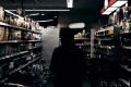 Person standing in a grocery store aisle surrounded by beverage and food shelves
