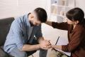 Therapist providing emotional support to a client during an individual counseling session