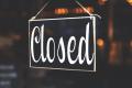 Closed sign hanging in a storefront window, representing barriers to treatment, missed opportunities, or emotional withdrawal