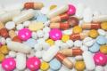 Assorted prescription medications including capsules, tablets, and pills on a white surface