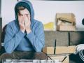 Person sitting with head in hands, showing emotional distress, depression, anxiety, or mental health struggles