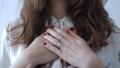 Person holding hands over chest symbolizing emotional healing, self-compassion, recovery, and mental health support