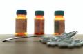 Prescription pill bottles and white tablets on a table, representing medication use and treatment