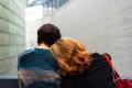 Two people leaning on each other for comfort and support, representing connection, healing, and recovery