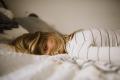 Woman lying on a bed appearing withdrawn and emotionally distressed