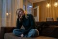 woman sitting on couch feeling discouraged after addiction treatment