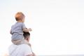 Father carrying a young child on his shoulders while walking outdoors