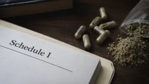 Capsules, powder, and a Schedule I document representing the federal crackdown on 7OH