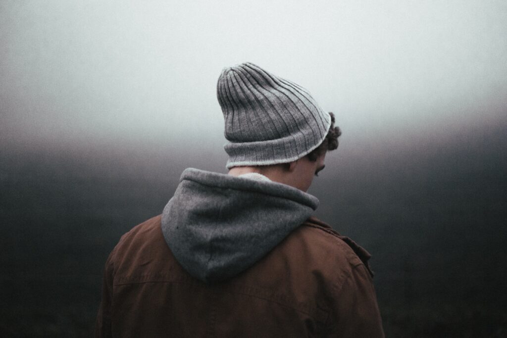 Person standing alone outdoors in reflection, representing emotional struggles and the recovery journey