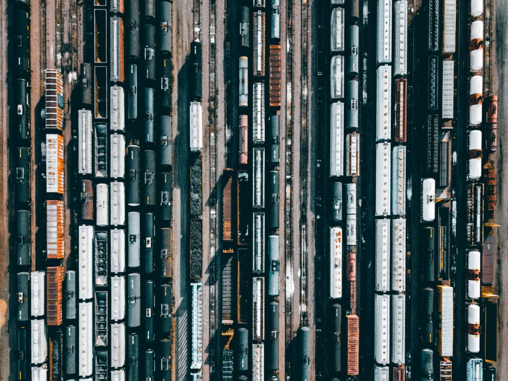 Aerial view of multiple freight trains and railcars lined up on parallel railway tracks