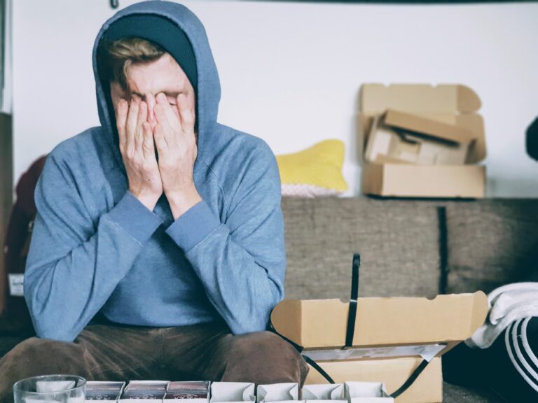 Person sitting with head in hands, showing emotional distress, depression, anxiety, or mental health struggles