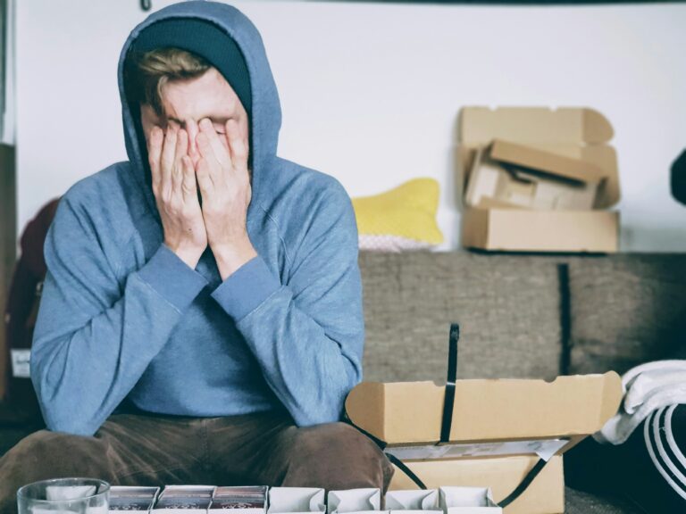 Person sitting with head in hands, showing emotional distress, depression, anxiety, or mental health struggles