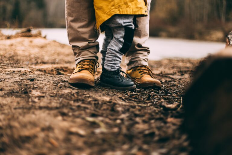 Adult and child standing together outdoors, symbolizing family support, parenting, and healing relationships