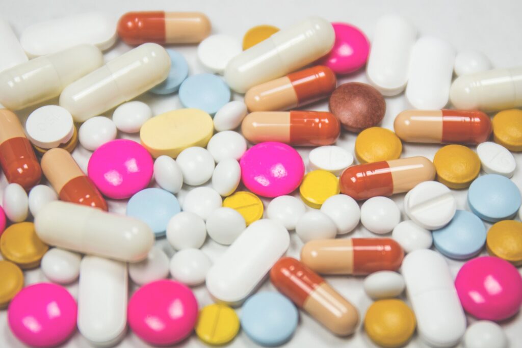Assorted prescription medications including capsules, tablets, and pills on a white surface