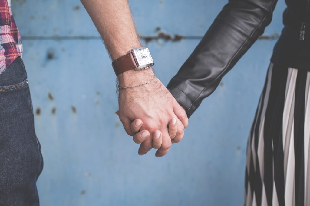 Two people holding hands, symbolizing connection, trust, and supportive relationships