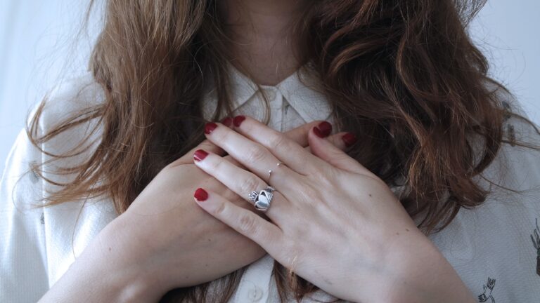 Person holding hands over chest symbolizing emotional healing, self-compassion, recovery, and mental health support