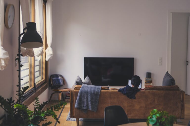 Person sitting alone in a quiet living room, representing solitude, reflection, mental health, and recovery at home
