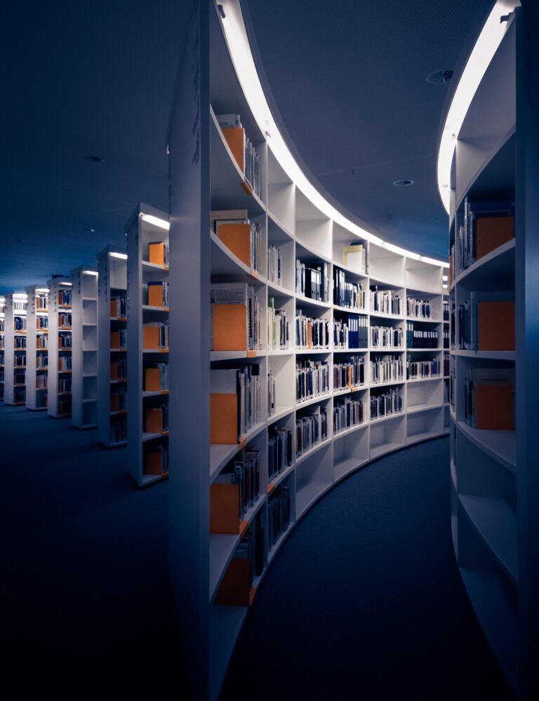 Curved library bookshelves filled with books in a quiet reading space, representing education, learning, and personal growth