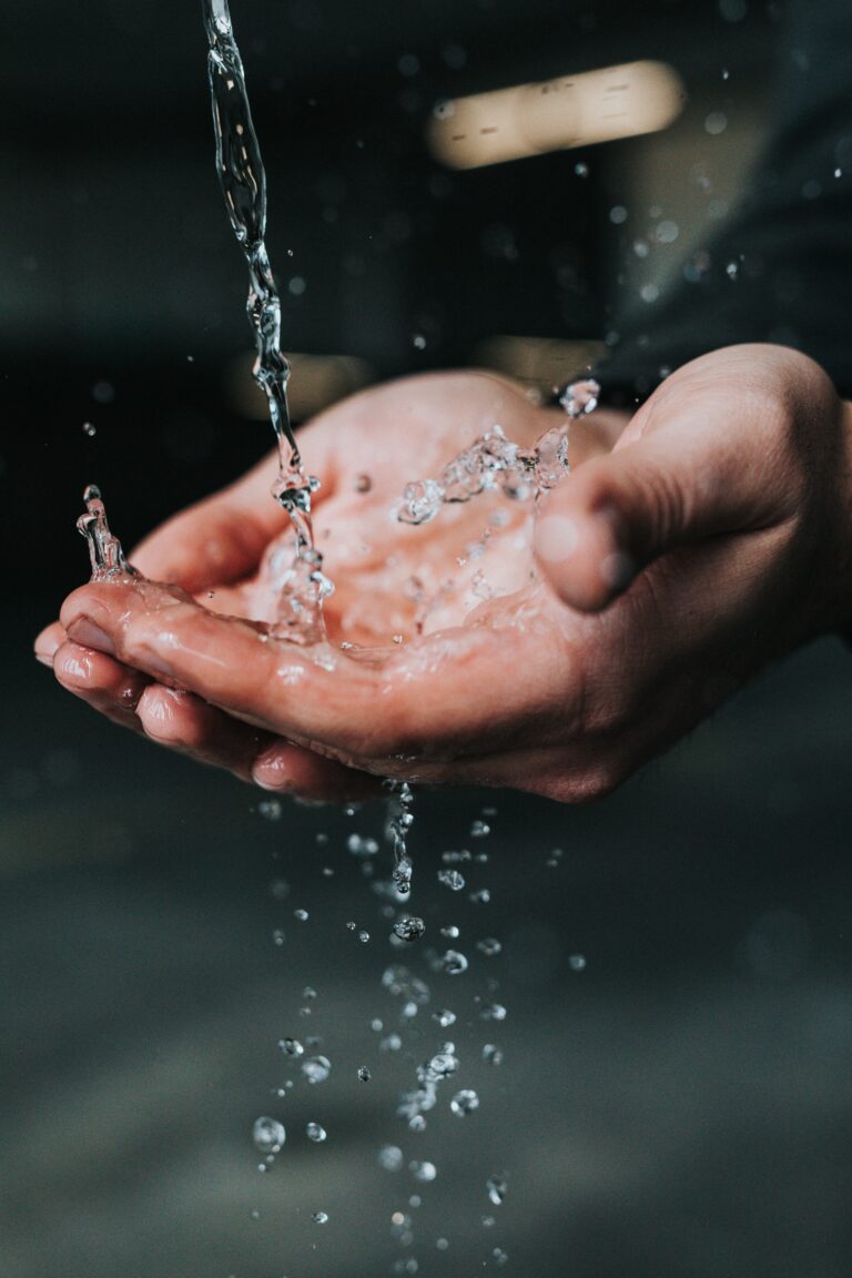 Water flowing into a person's cupped hands
