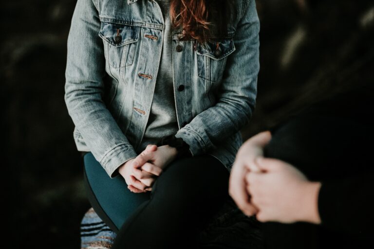 Two people engaged in a private counseling conversation focused on emotional support and recovery