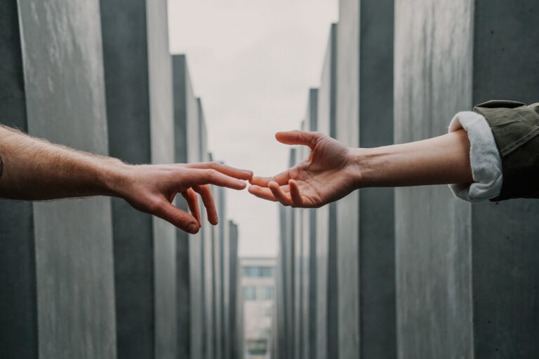 Two people reaching toward each other, symbolizing connection, support, healing, and recovery from trauma